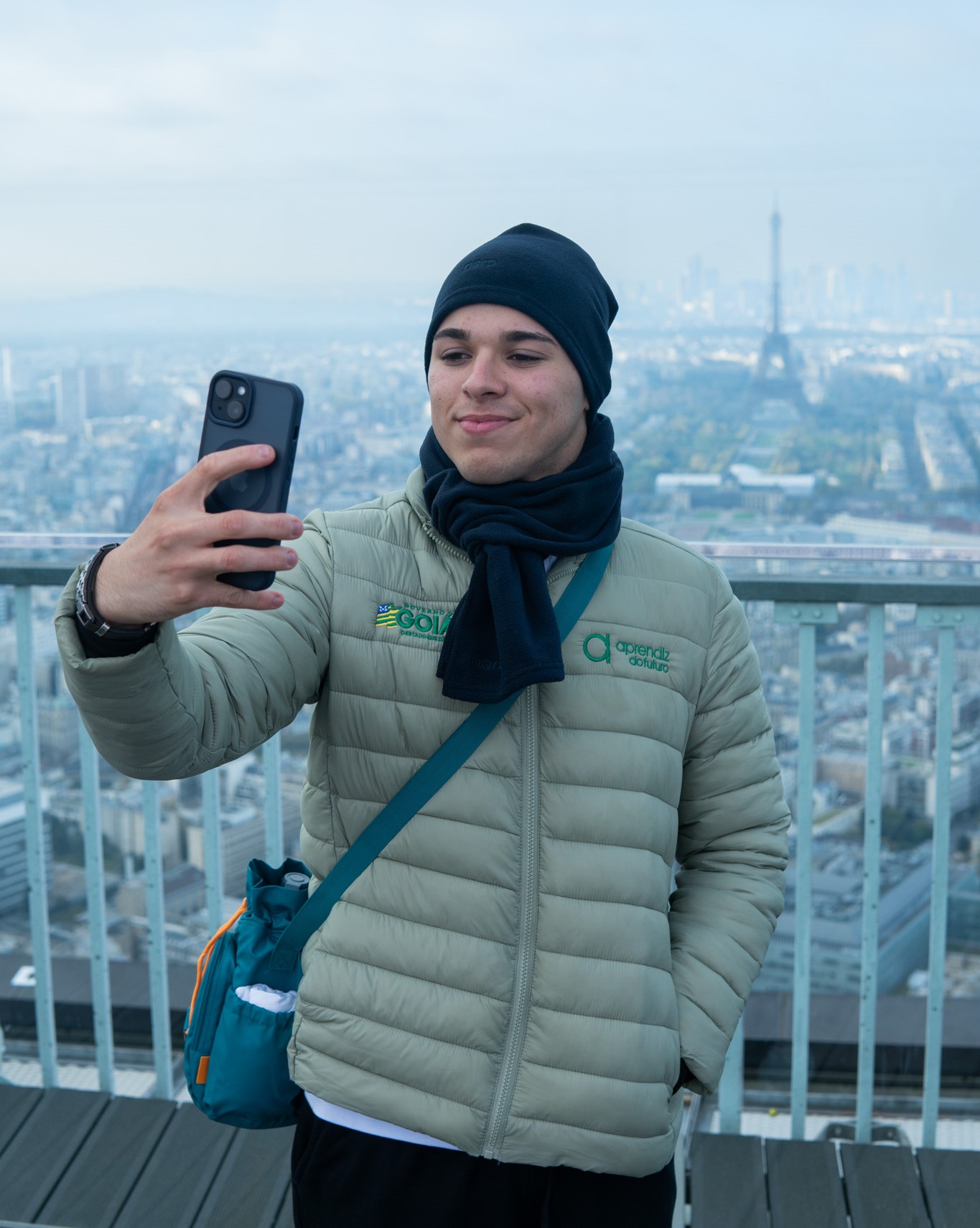 Jovem aprendiz de Goiás tira uma selfie com a Torre Eiffel ao fundo, durante intercâmbio internacional promovido pelo Programa Aprendiz do Futuro