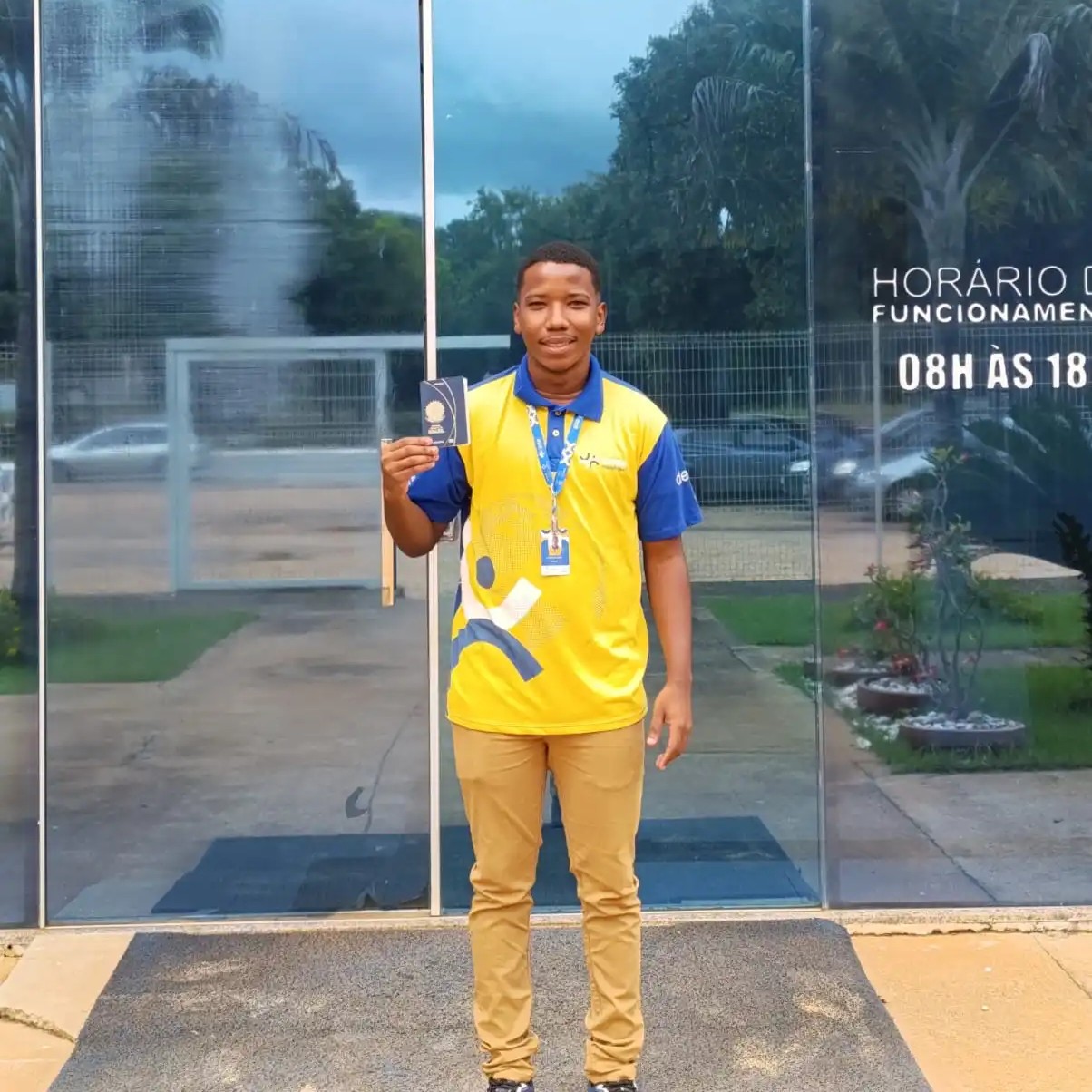 jovem trabalhador James com seu passaporte